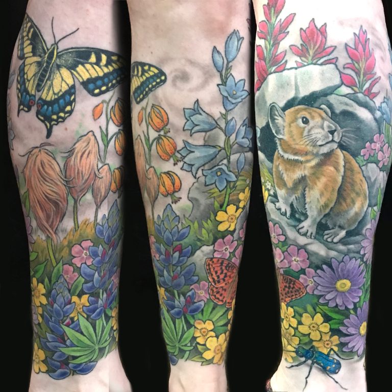 Colorful nature-themed tattoo with flowers, a butterfly, a pika on rocks, and foliage.